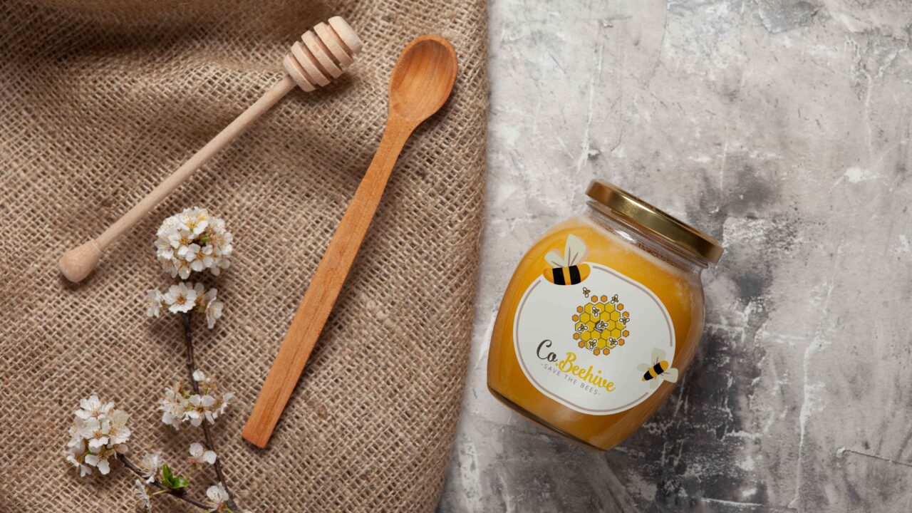 a jar of honey next to a wooden spoon make by af studio