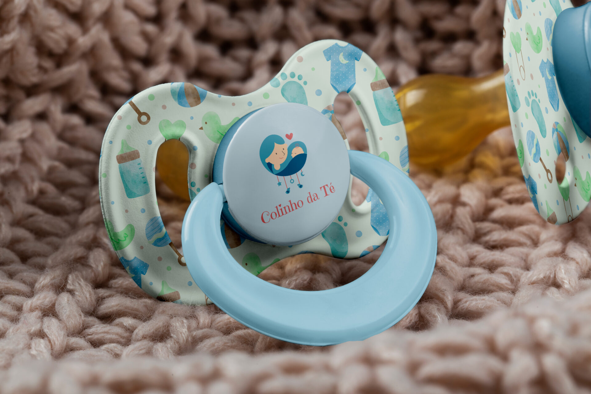 a baby pacifier sitting on top of a blanket make by adfstudio